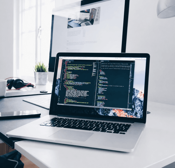 Laptop displaying code in a modern workspace
